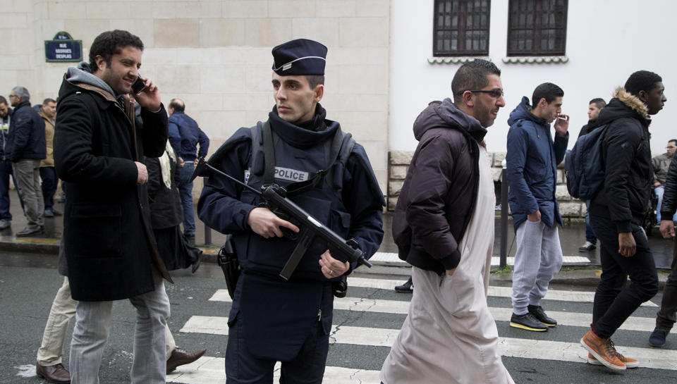 FILE - In this Friday Jan. 9, 2015 file photo, a French police officer stands guard outside the Grand Mosque as people arrive for Friday prayers, Paris. Firebombs and pigs' heads are being tossed at mosques and women in veils have been insulted in a surge of anti-Muslim acts since last week's murderous assault on the newsroom of a satirical Paris paper, according to a Muslim who tracks such incidents in France. France's large Muslim population risks becoming collateral damage in the aftermath of the three attacks by French radical Islamists who killed 17 people. Muslims in other European countries also won't be spared, some Muslim leaders and experts say. Concern about a backlash against Muslims was discussed Monday Jan. 13, 2015, during a meeting on counter-terrorism measures at the Interior Ministry. (AP Photo/Michel Euler, File)