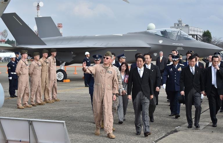 Japan's Prime Minister Shinzo Abe (C-R) inspects a mock-up F35A fighter (rear) as part of a static display during a review ceremony at the Japan Air Self-Defense Force's Hyakuri air base at Omitama, Ibaraki prefecture, on October 26, 2014