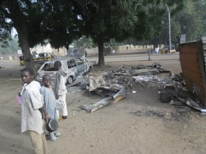 Children stand near the scene of an explosion in a mobile phone market in Potiskum, Nigeria, Monday Jan. 12, 2015. Two female suicide bombers targeted the busy marketplace on Sunday. (AP Photo/Adamu Adamu) 